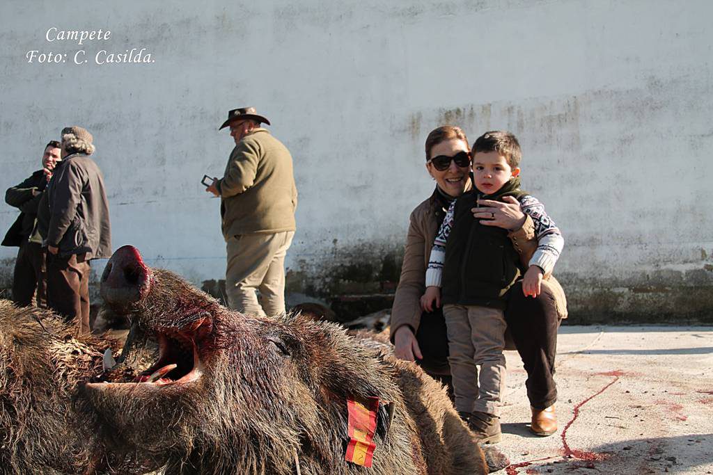 Un futuro montero y su madre junto a uno de los jabalíes cobrados en Campete.